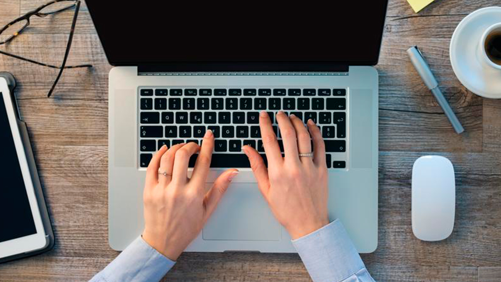 Overhead view of a set of hands typing on a laptop.