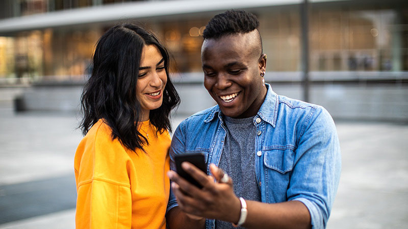 man and woman looking at their phone