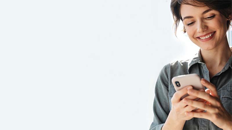 mujer sonriendo mirando su telefono