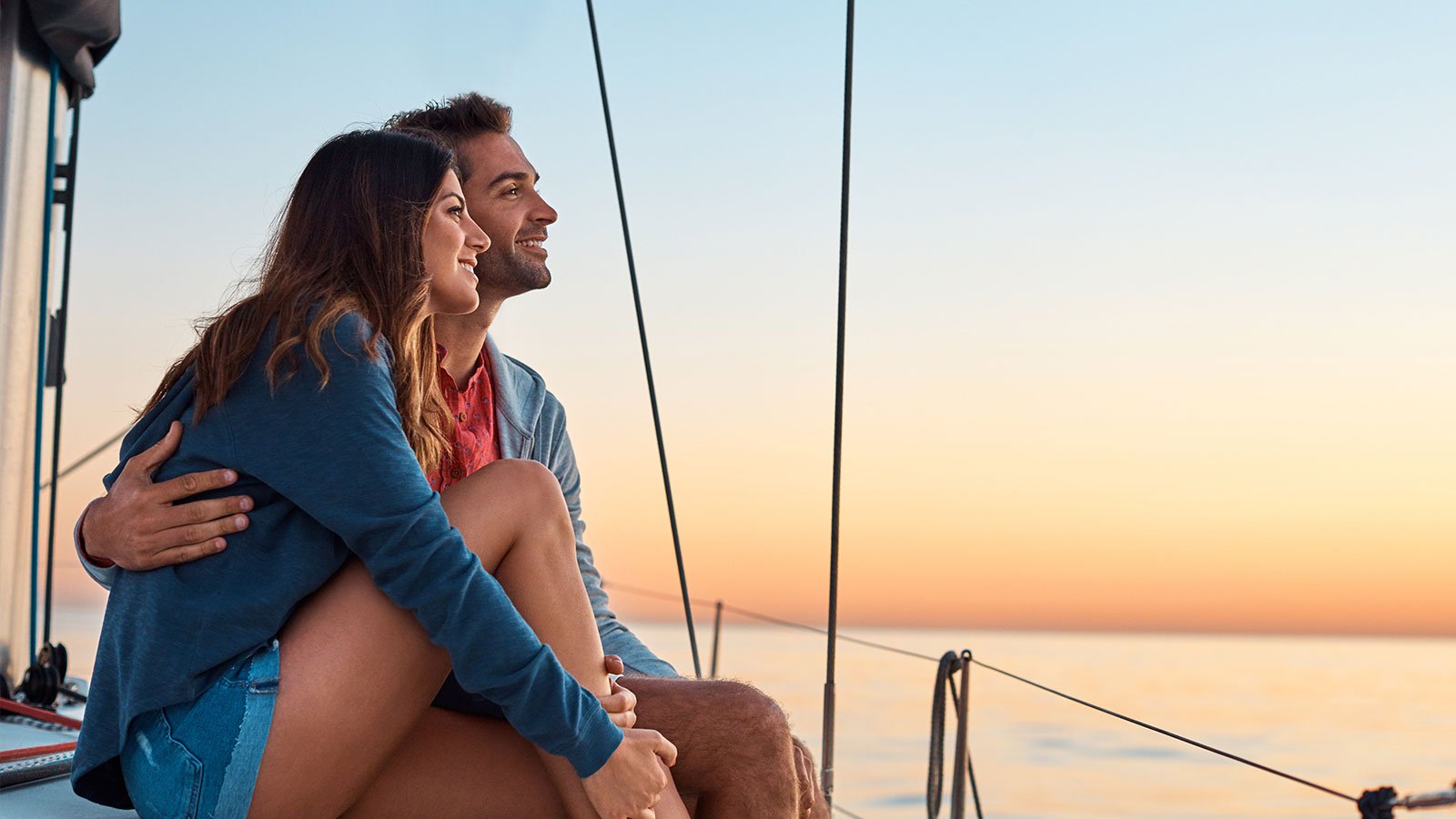 Mujer y hombre abrazados mirando atardecer