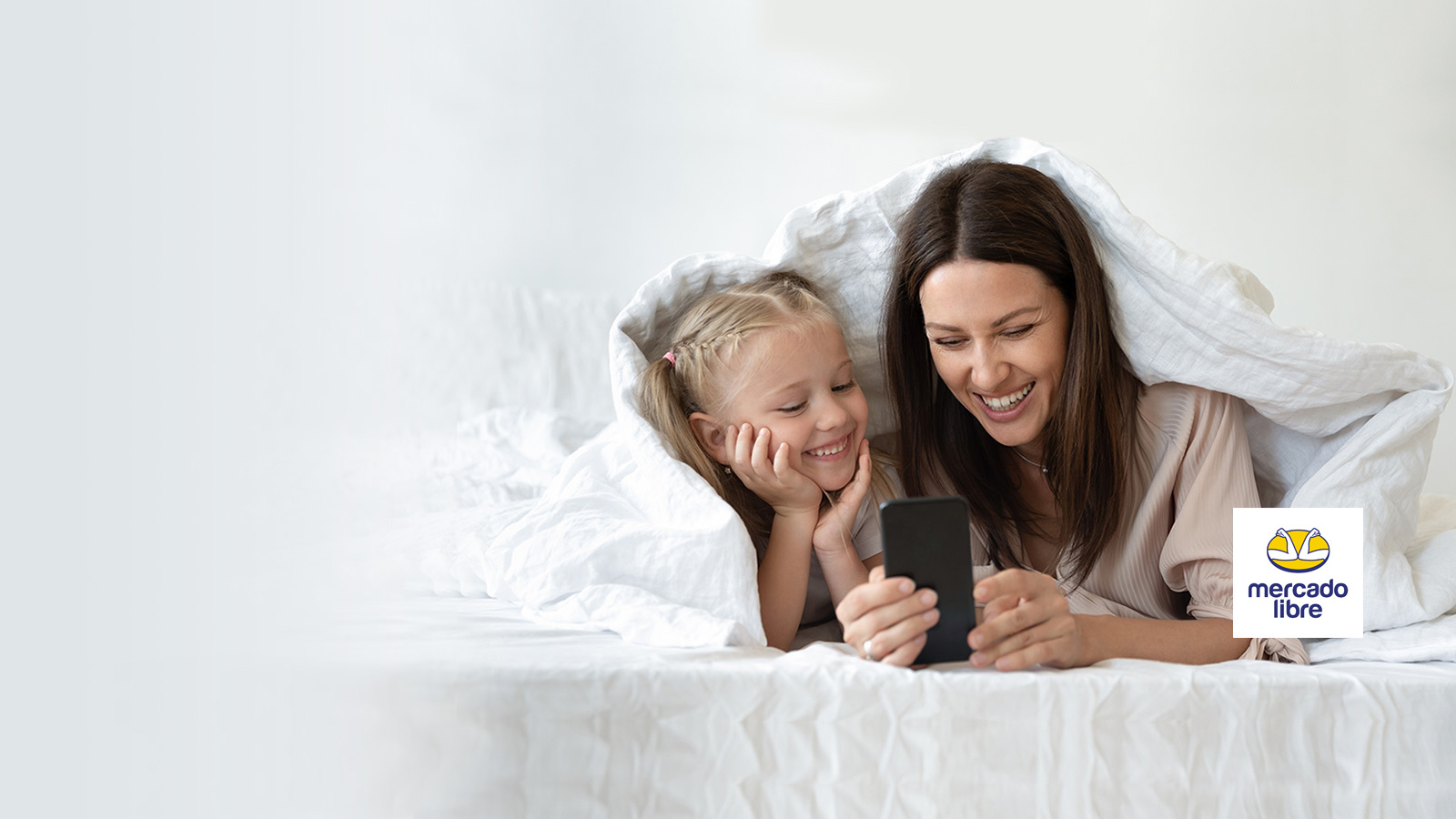 Madre e hija sonriendo mirando el teléfono móvil