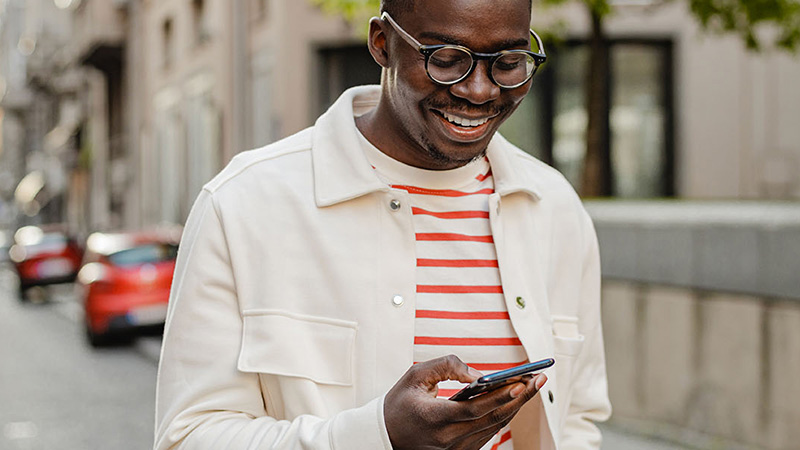 Hombre sonriendo mirando su smartphone
