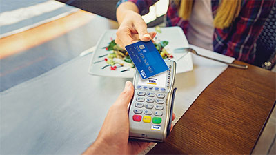 Persona pagando con su tarjeta Visa sin contacto